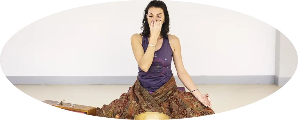 Femme m&eacute;ditant en position assise, pratiquant un exercice de respiration.