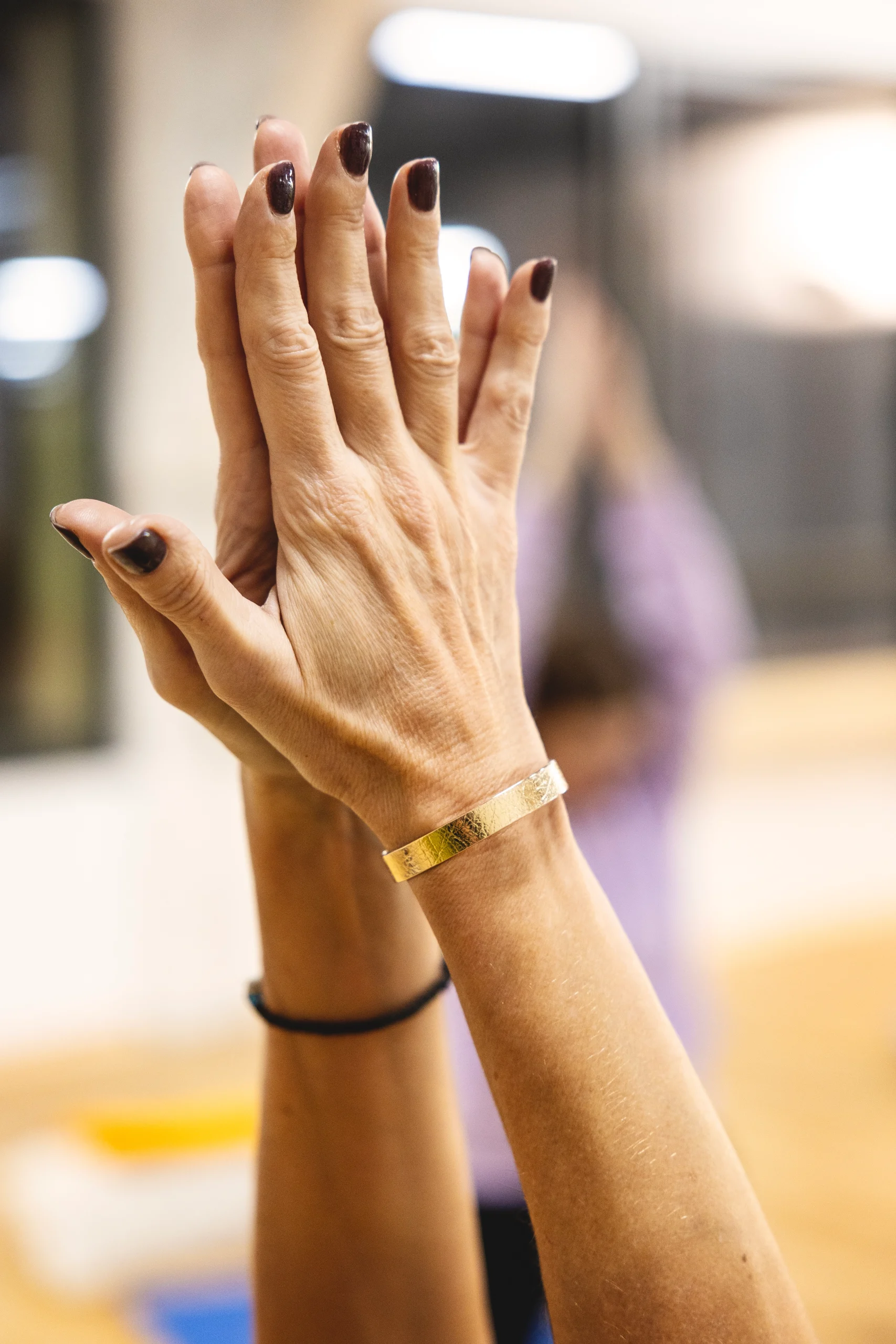 Deux mains jointes en pri&egrave;re avec un bracelet dor&eacute;.