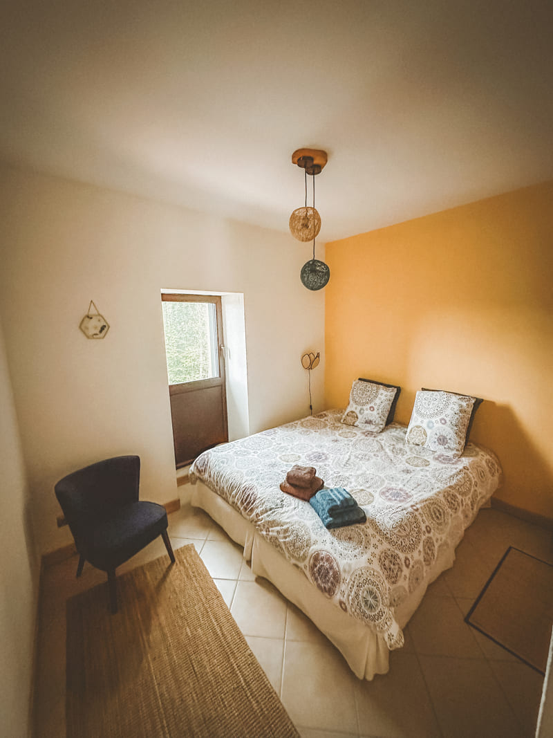 Chambre avec lit double, murs clairs et décoration minimaliste.