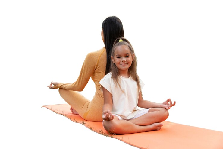 Enfant et adulte m&eacute;ditant en position de yoga sur un tapis orange.