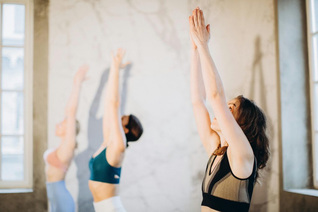 Femmes pratiquant le yoga dans une salle lumineuse.