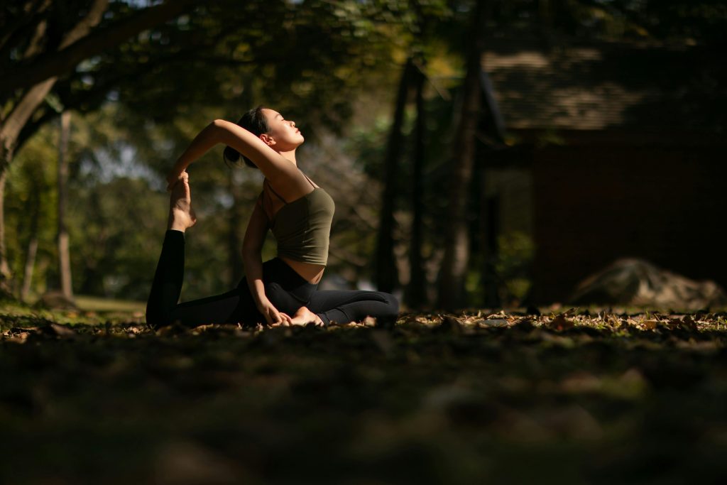 Femme faisant du yoga dans un parc ombrag&eacute;.