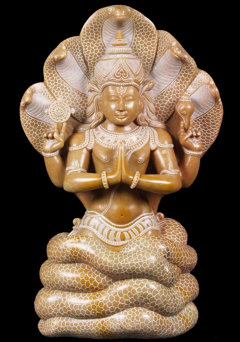 Statue de Patanjali avec tête et bras de serpent, en position méditative.