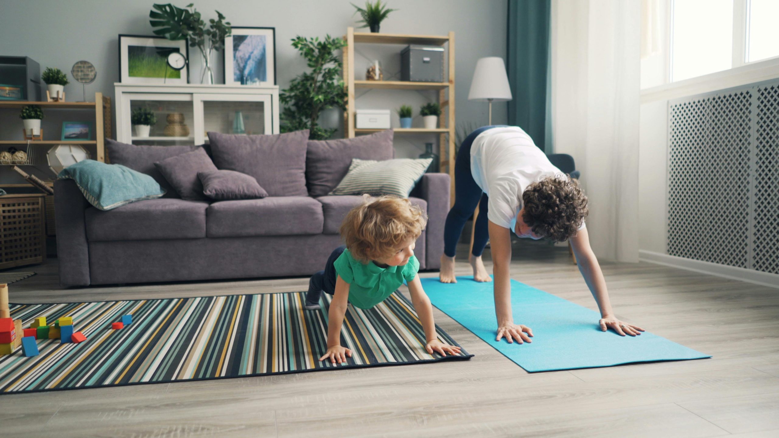 Enfants pratiquant le yoga sur des tapis dans un salon lumineux.