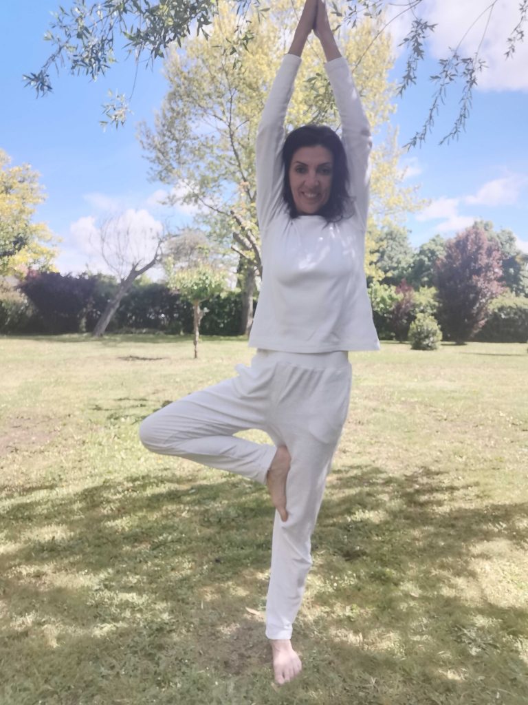 Personne en posture de yoga Vrksasana dans un parc ensoleill&eacute;.